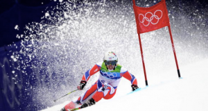 Olympic skier going down a mountain and rounding a marker